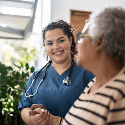 Home caregiver helping senior woman walking at home nursing home staff